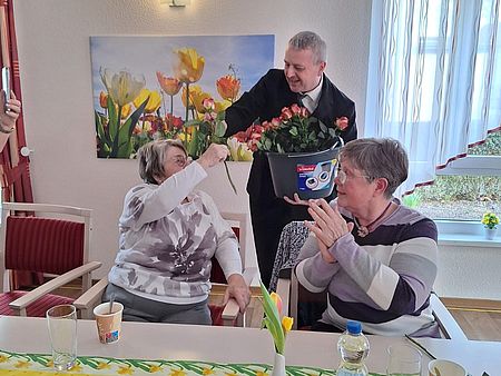 Der "Sexy-Flower-Boy" überreicht zum Frauentag Rosen Ein Mann überreicht einer Frau eine Rose