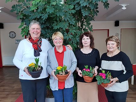 Der neu gewählte Vorstand des DRK-Ortsvereins Eilsleben Vier Frauen stehen nebeneinander und halten jeweils eine Schale mit Blumen in der Hand
