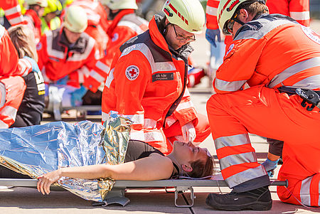 Sanitäter üben den Ernstfall Zwei Sanitäter hocken über einer Person auf einer Trage