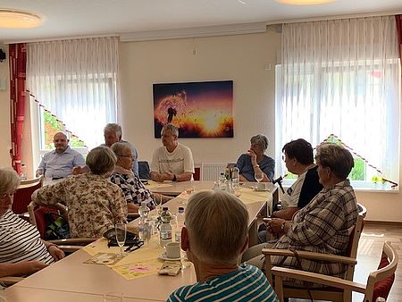 Politdialog beim Kaffeetreff in Osterweddingen mehrere Personen sitzen an einer Tafel und hören einem Redner zu