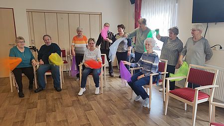 Gymnastik mit Tüchern in Osterweddingen Mehrere Senioren sitzen oder stehen und machen Sport mit bunten Tüchern