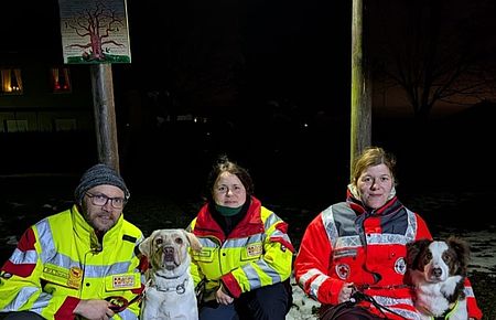 In Rottmersleben gab es eine gemeinsame Übung von DRK und ASB drei Personen in Einsatzkleidung hocken neben ihren Hunden